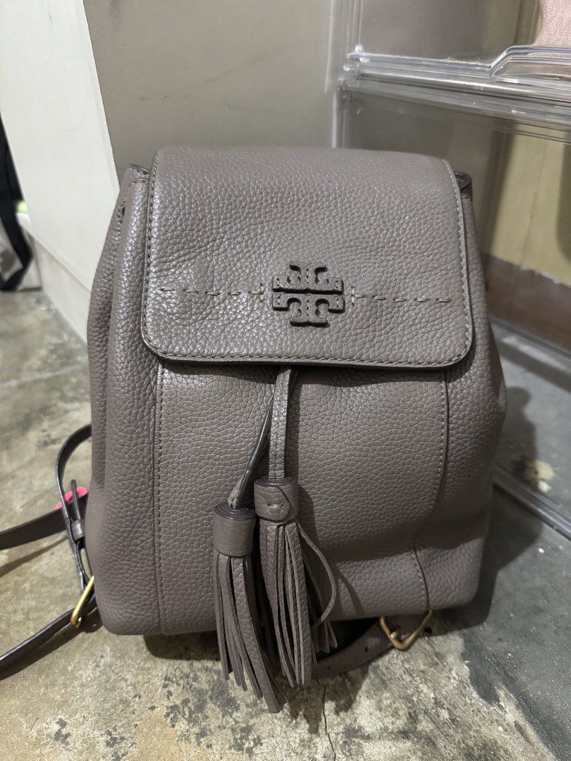 Tory Burch Thea Mini Backpack (Category: Luxury Bags & Wallets) located in Manila. Submitted by jizamarie (Listing ID 1468615376, Image 3). Description: The perfect everyday hands-free neutral! Beautiful French Gray pebbled leather with the signature embossed logo and tassels. ✨ DM for inquiries or more close-up details! 📥.