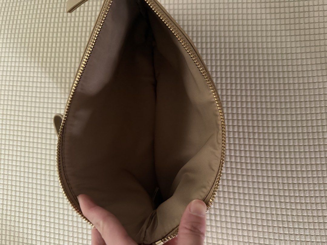 Tory Burch Wristlet Clutch Tan Leather (Category: Luxury Bags & Wallets) located in Paranaque City. Submitted by balofies (Listing ID 1468661305, Image 3). Description: - Brand: Tory Burch - Material: Premium tan leather with fabric-lined interior - Features: Matching wrist strap, embossed logo circle, secure zip top closure - Condition: Overall clean inside and out, with a few tiny scuffs near the bottom back edge - Usage: Compact size, ideal fo