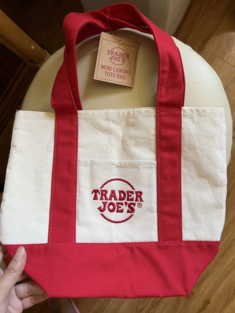 Trader Joe's Mini Canvas Tote Bag Red (Category: Tote Bags) located in Rizal. Submitted by s0apandglory (Listing ID 1468558798, Image 1). Description: - 100% Authentic Trader Joe's mini canvas tote bag - Color: Red and off-white with matching red bottom base and sturdy handles - Features a handy front pocket with embroidered Trader Joe's logo - Made of heavy-duty, durable cotton material - Brand new with original paper store tag still attached - 
