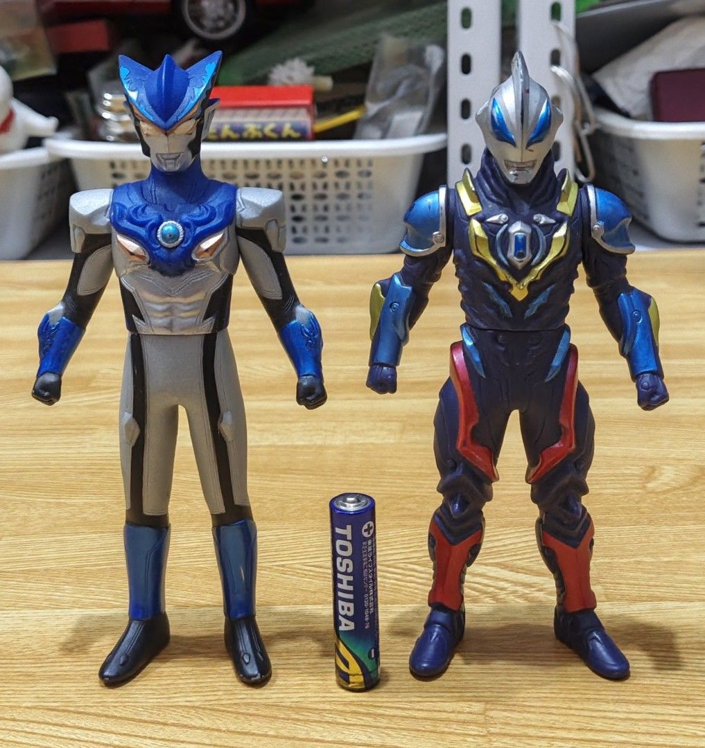 Ultraman Action Figures Bundle Set (Category: Figurines & Statues) located in San Pedro. Submitted by toydibz (Listing ID 1468534514, Image 2). Description: - Assorted Ultraman vinyl figures in different sizes and poses - Includes classic red/silver designs and newer forms with blue/dark armor - AA battery included in photos to show scale - Condition: Has minor paint scuffs and wear marks from past play - Great bundle for fans and collectors - Mo