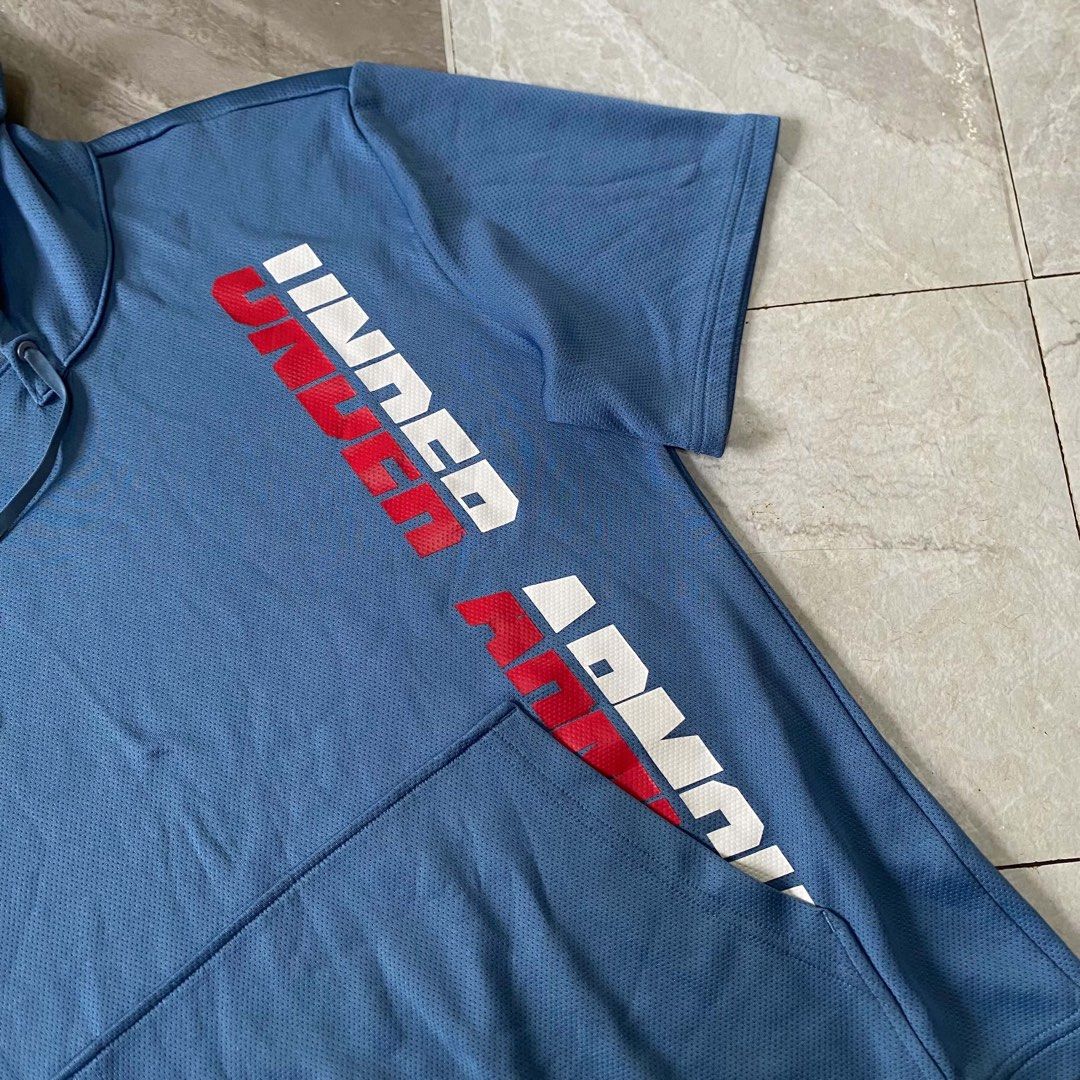 Under Armour Performance Short Sleeve Blue Hoodie (Category: Activewear) located in Butuan. Submitted by jc13thrifts (Listing ID 1468709271, Image 3). Description: - Brand: Under Armour - Color: Light Blue - Style: Performance short sleeve hoodie / athletic wear - Material: Breathable, mesh-like athletic fabric - Features: Adjustable drawstring hood, front kangaroo pocket with logo patch, and vertical UA text graphic on the side.