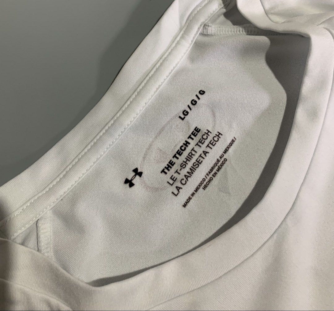 Under Armour The Tech Tee White (Category: Tshirts & Polo Shirts ) located in Cebu City. Submitted by stuff_paid (Listing ID 1468639955, Image 2). Description: - Brand: Under Armour - Item: The Tech Tee - Color: White - Size: Large (L) - Condition: Excellent / Pre-loved (as applicable) - Material: Lightweight, breathable athletic fabric - Details: Short sleeves, silver logo on chest and back collar, interior QR code tag - Style: Clean, plain desi