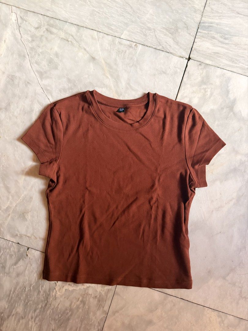 Uniqlo Mini Tshirt (Category: Shirts) located in Calamba. Submitted by prelovedbyanka (Listing ID 1468516293, Image 1). Description: - Brand: Uniqlo - Color: Brown - Fit: Comfortable stretch fit, cropped length - Details: Ribbed fabric, classic crew neckline - Condition: Excellent, no stains or holes - Style: Great everyday basic, easy to pair with high-waisted bottoms.