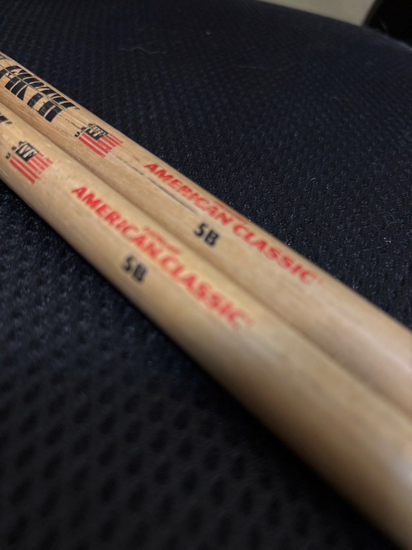 Vic Firth American Classic 5B Drumsticks (Category: Musical Instruments) located in Malabon City. Submitted by luxgoals (Listing ID 1468522014, Image 3). Description: - Brand/Model: Vic Firth 5B - Material: Genuine Hickory with standard wooden tips - Condition: Used, with minor stick marks; logos and size markings still clearly visible - Feel: Standard weight and balance - Best For: General drumming practice and band rehearsals - Meet-ups or ship