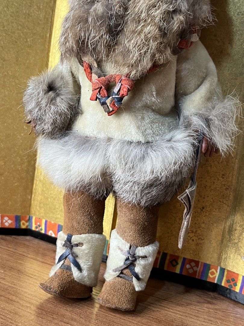 Vintage Inuit Eskimo Doll with Fur clothes (Category: Plushies & Soft Toys) located in Gapan. Submitted by lunashop14 (Listing ID 1468688321, Image 3). Description: - Vintage Inuit-style doll featuring a dark complexion and expressive brown eyes - Dressed in a thick, stylish fur-trimmed parka with a cozy matching hood - Accented with a braided leather necklace and carrying a small pouch or tool accessory - Fitted with detailed suede-like mukluks 