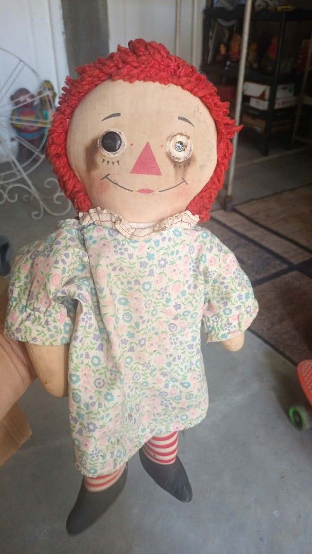Vintage Knickerbocker Raggedy Ann Doll (Category: Babies & Kids Fashion) located in Mandaluyong City. Submitted by LEATHERFACE (Listing ID 1468549665, Image 1). Description: - Vintage Knickerbocker Raggedy Ann doll - Size: Approx. 16 inches tall - Features signature red yarn hair and embroidered facial features - Wears a charming floral dress, striped socks, and black shoes - Condition: Shows vintage wear around the face with one missing black ey