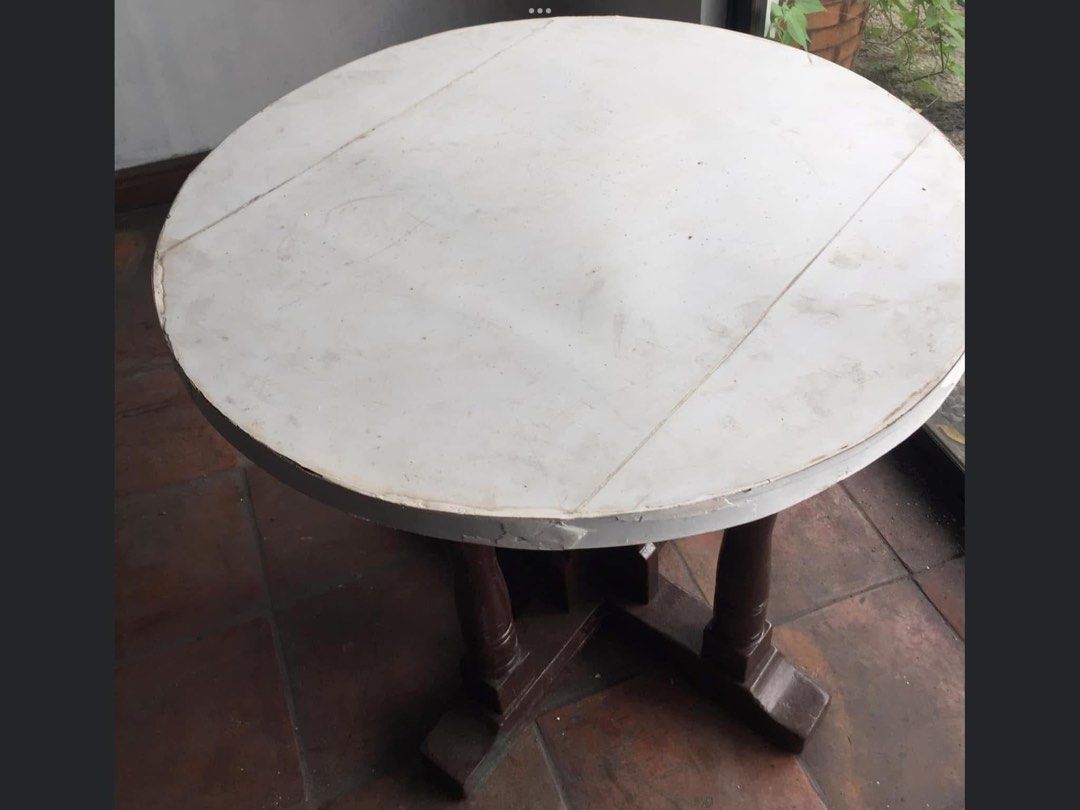 Vintage Round Wooden Dining Table with White Top (Category: Tables & Sets) located in Manila. Submitted by roberto.enriquez (Listing ID 1468690236, Image 3). Description: - Type: Round wooden dining table - Base: Dark brown carved pedestal with four supporting legs - Tabletop: White painted finish with noticeable surface scratches and scuffs - Condition: Sturdy solid wood build, shows visible wear from previous use - Ideal For: DIY repainting or 
