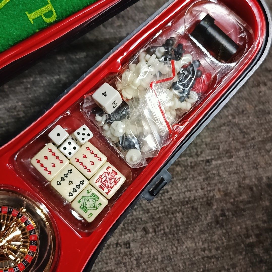 Violin-Shaped Travel Game Case (Category: Vintage Collectibles) located in Meycauayan. Submitted by ka_luma (Listing ID 1468700608, Image 3). Description: violin-shaped travel game case (often sold as a 12-in-1 casino or travel game set, such as Traveler's Games or similar novelty packs) containing a mini roulette wheel, poker chips, playing cards, dice, a solitaire/board game grid, and felt play mats.