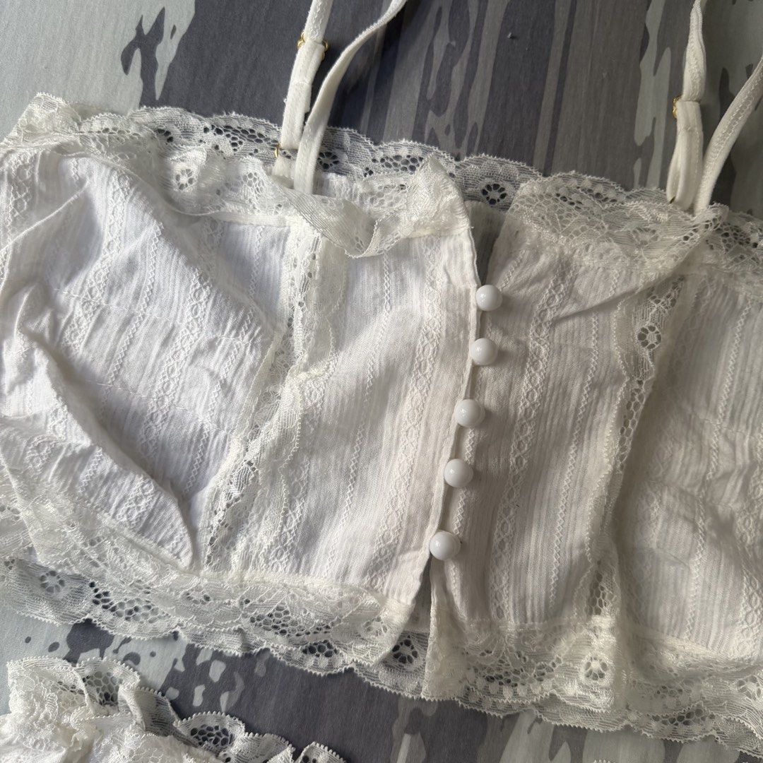 White Lace Pajama Set (Category: Undergarments & Loungewear) located in Marikina City. Submitted by lou.and.trio (Listing ID 1468568541, Image 3). Description: - Condition: Used once - Color: White with subtle vertical textured stripes - Set includes: Cami top and matching shorts - Top features: Adjustable straps and cute pearl-like front buttons - Shorts features: Elastic waistband and ruffled lace hems - Fit: For small frames 26” - 28” - Bought