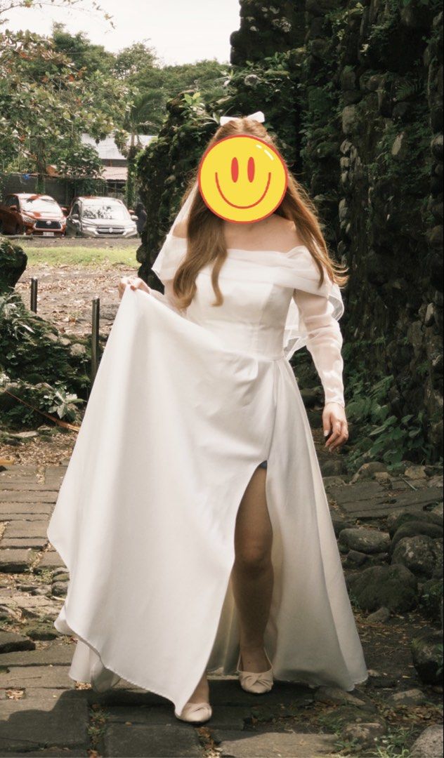 White Off-Shoulder Wedding Dress With slit from Vietnam (Category: Evening dresses & gowns) located in Daet. Submitted by ilovetakoyakiii (Listing ID 1468570103, Image 3). Description: - Color: White - Design: Off-shoulder draped style with sheer long sleeves - Skirt: Floor-length with a chic high leg slit - Condition: Worn once for an outdoor photoshoot Waits - 30 Bust - 36 Once lang nagamit. Quality yung tela nya makapal at medyo mabigat. May b