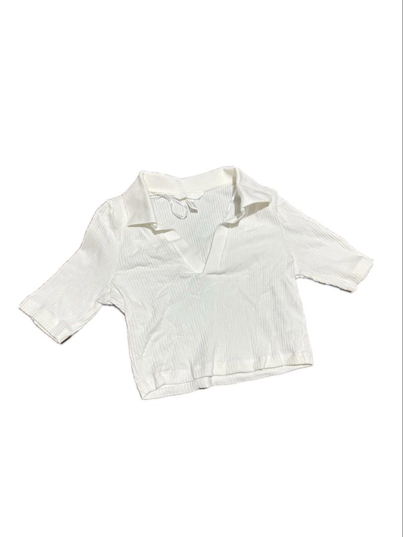 White Ribbed V-Neck Polo Crop Top (Category: Shirts) located in Manila. Submitted by yumidrobeee (Listing ID 1468546230, Image 1). Description: - Style: White ribbed knit crop top with short sleeves - Design: Folded collar with a chic V-neck opening and cropped fit - Comfort: Made with stretchy, super comfortable fabric - Condition: Clean, well-maintained - Styling Tip: Looks great paired with high-waisted jeans or skirts.