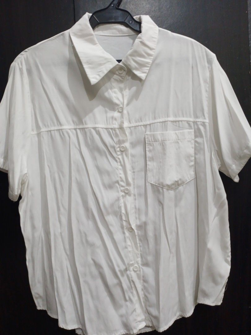 White short sleeve button down shirt with chest pocket (Category: Shirts) located in Manila. Submitted by ggarage.sale (Listing ID 1468689305, Image 3). Description: - Color: Plain White - Style: Short sleeve button-down, relaxed fit - Features: Collared neckline, front button closure, single left chest pocket, straight hemline - Fabric: Lightweight (note: slightly wrinkled from storage) - Versatility: Easy to pair with jeans or skirts.