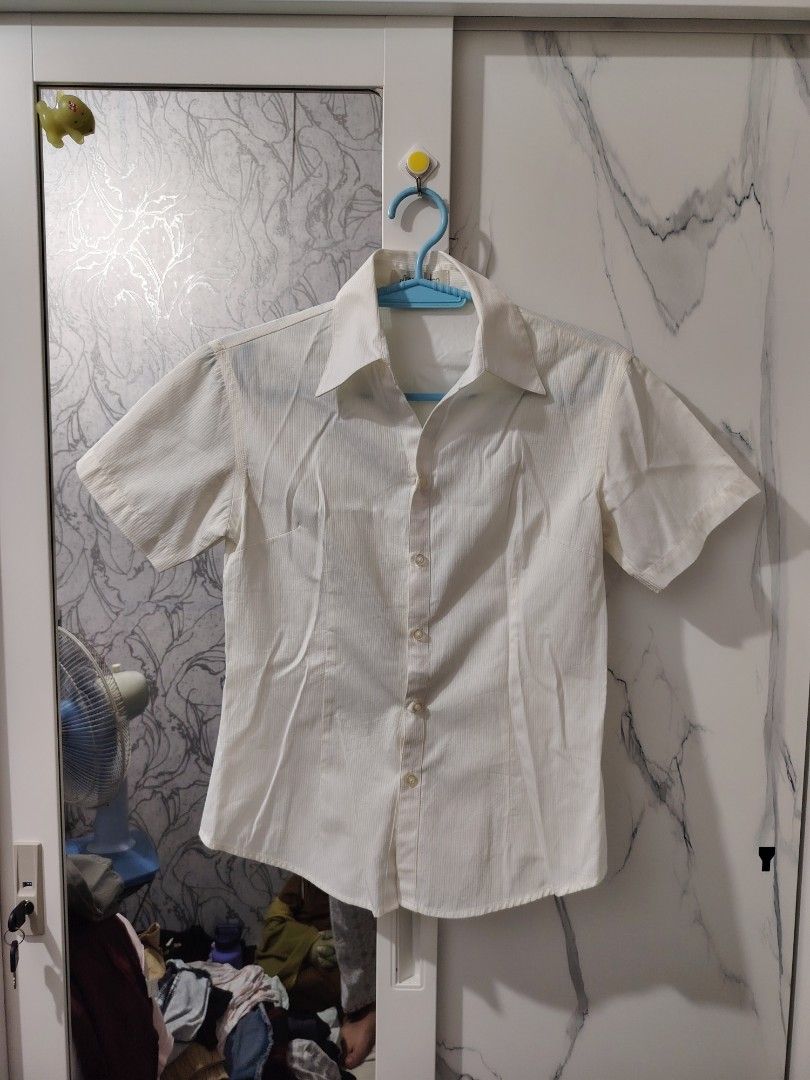 White short sleeve button up collared shirt (Category: Blouses) located in Valenzuela. Submitted by zealstar.48eb73 (Listing ID 1468667891, Image 1). Description: - Size: Fits XS-Semi Medium - Color & Pattern: White with subtle stripes - Fit: Fitted silhouette with classic collar - Versatility: Easy to match with skirts or trousers for casual or smart looks - Condition: Worn once, still in great shape - Mode of Payment: GCash or BPI - Shipping: F
