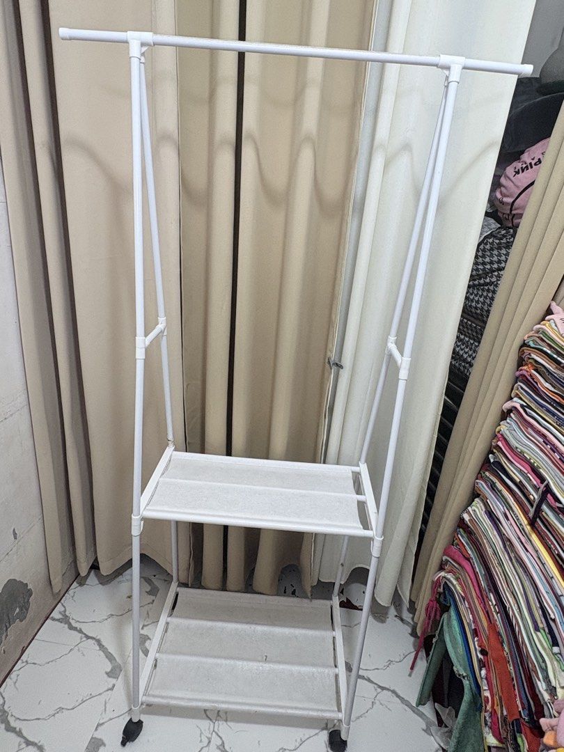 White Triangle Clothes Rack With Shelves And Wheels (Category: Shelves, Cabinets & Racks) located in Quezon City. Submitted by geminiselection (Listing ID 1468565362, Image 1). Description: Issue: nagkaroon ng small hole sa baba, please check last pic. Maliit lang po, doesn’t affect the functionality of the item. - with wheels, still working.