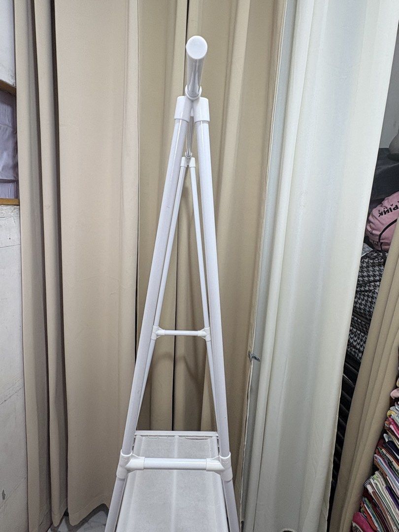 White Triangle Clothes Rack With Shelves And Wheels (Category: Shelves, Cabinets & Racks) located in Quezon City. Submitted by geminiselection (Listing ID 1468565362, Image 2). Description: Issue: nagkaroon ng small hole sa baba, please check last pic. Maliit lang po, doesn’t affect the functionality of the item. - with wheels, still working.