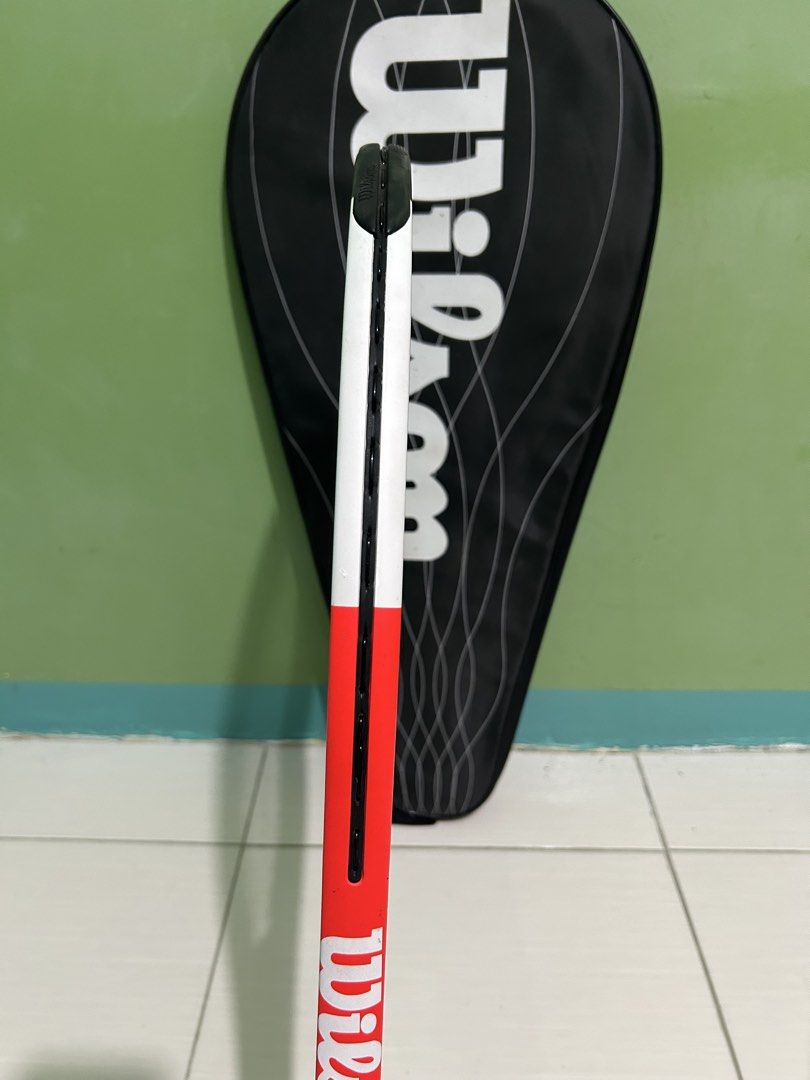 Wilson Pro Staff Comp Tennis Racket with Cover (Category: Racket and Ball Sports) located in Imus. Submitted by storiesforstrays (Listing ID 1468638718, Image 3). Description: Wilson Pro Staff Comp tennis racket. Orange, white, and black colorway. Strung and ready to play. Includes the original Wilson black racket cover bag with zip closure. Frame is clean with minimal scuffs. .