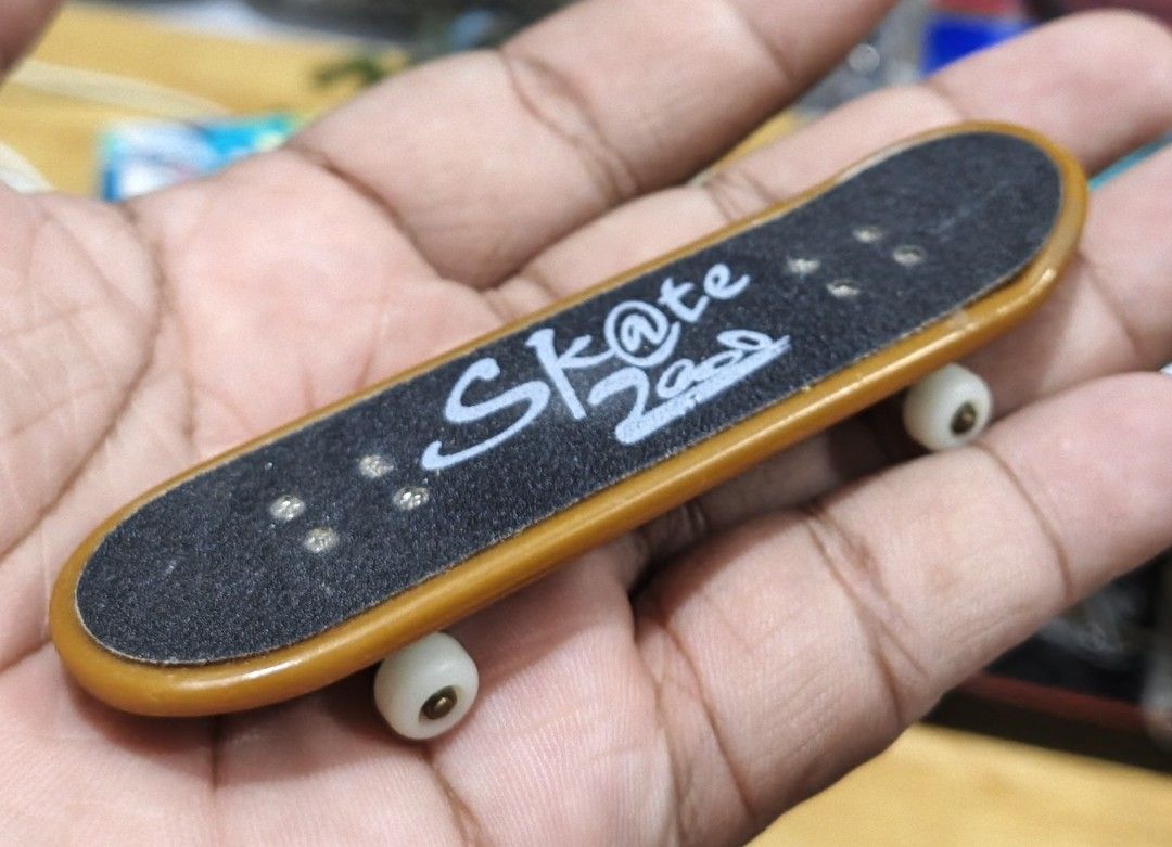 World Peace Fingerboard Mini Skateboard (Category: Skates, Rollerblades & Scooters) located in San Pedro. Submitted by toydibz (Listing ID 1468538375, Image 3). Description: - Type: Standard tech deck style fingerboard - Bottom Design: World Peace graphic with blue stars and a pink peace sign - Top Grip: Black grip tape featuring white 'Sk@te' and barcode print - Hardware: White wheels and metal trucks attached - Use: Fun little toy perfect for y