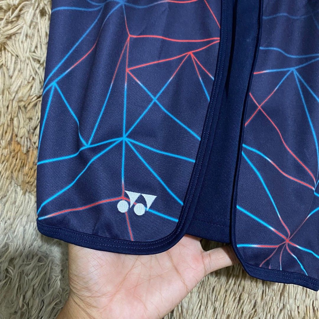 Yonex Very Cool Geometric Athletic Shorts Navy Blue (Category: Shorts) located in Butuan. Submitted by jcuabs041302 (Listing ID 1468517708, Image 3). Description: - Brand: Yonex - Color: Navy blue with red and blue geometric lines - Size: Asia L (Europe M, USA S) - Material: 100% polyester with Very Cool technology fabric lining - Features: Elastic waistband with adjustable drawstring, lightweight, and breathable - Care: Machine washable - Condit