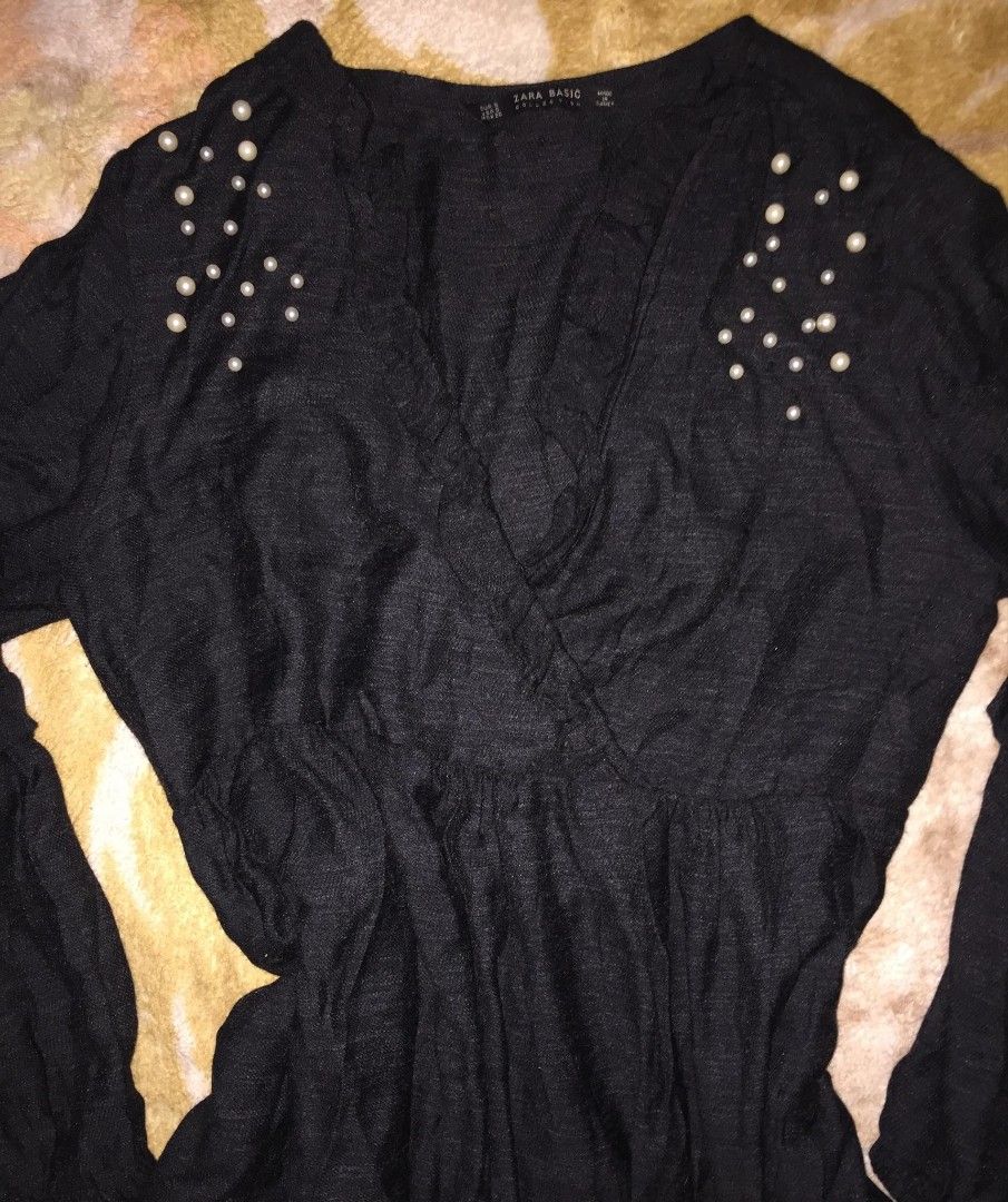 ZARA Basic Black Flowy Mini Dress (Category: Dresses) located in Dasmarinas. Submitted by pepperronnie (Listing ID 1468584789, Image 2). Description: This is a Zara Basic black flowy mini dress with pearl details 🖤 Style Breakdown: - Silhouette: Wrap V-neck, empire waist, A-line mini skirt — very flattering & forgiving fit ​ - Sleeves: Billowy balloon sleeves with ruffled cuffs — romantic, boho vibe ​ - Details: Faux pearl embellishments at shou