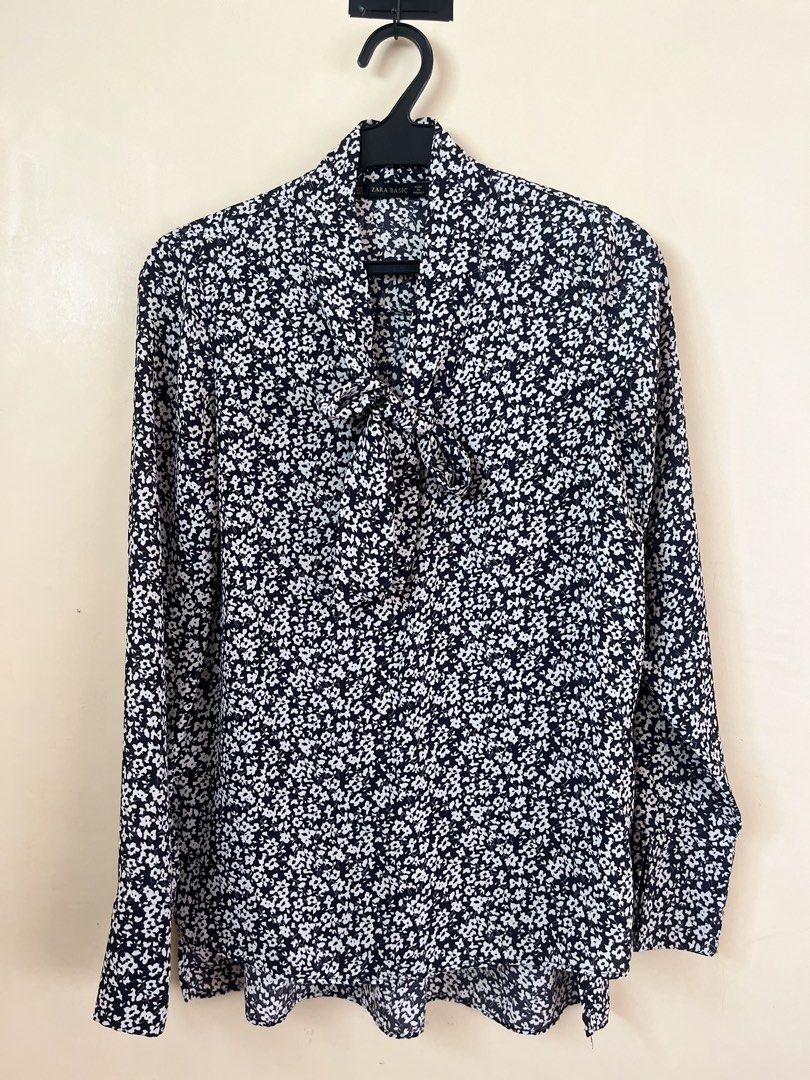 Zara Basic Black White Floral Pussy Bow Blouse (Category: Blouses) located in Binan City. Submitted by hannahbanana928 (Listing ID 1468710707, Image 2). Description: - Brand: Zara Basic - Design: Black with all-over white floral print - Features: Long sleeves, built-in tie neck/pussy bow detail - Material: Lightweight, comfortable, and easy to wear - Style: Buttonless slip-on - Versatility: Perfect for work or casual days out with jeans - Can fit