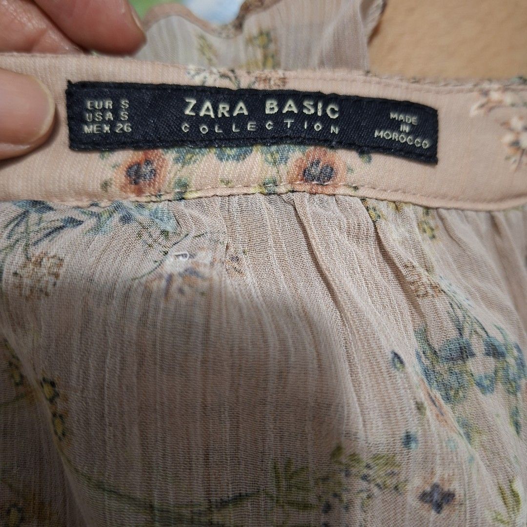 Zara Basic Floral Long Sleeve Blouse Size S (Category: Longsleeves) located in Imus. Submitted by jgz21 (Listing ID 1468673231, Image 2). Description: - Brand: Zara Basic - Color: Pinkish beige with ditsy floral print - Size: S (fits true to size) - Material: Lightweight fabric - Origin: Made in Morocco - Details: Long sleeves with ruffled neckline and cuffs - Condition/Use: Great casual piece for everyday wear.