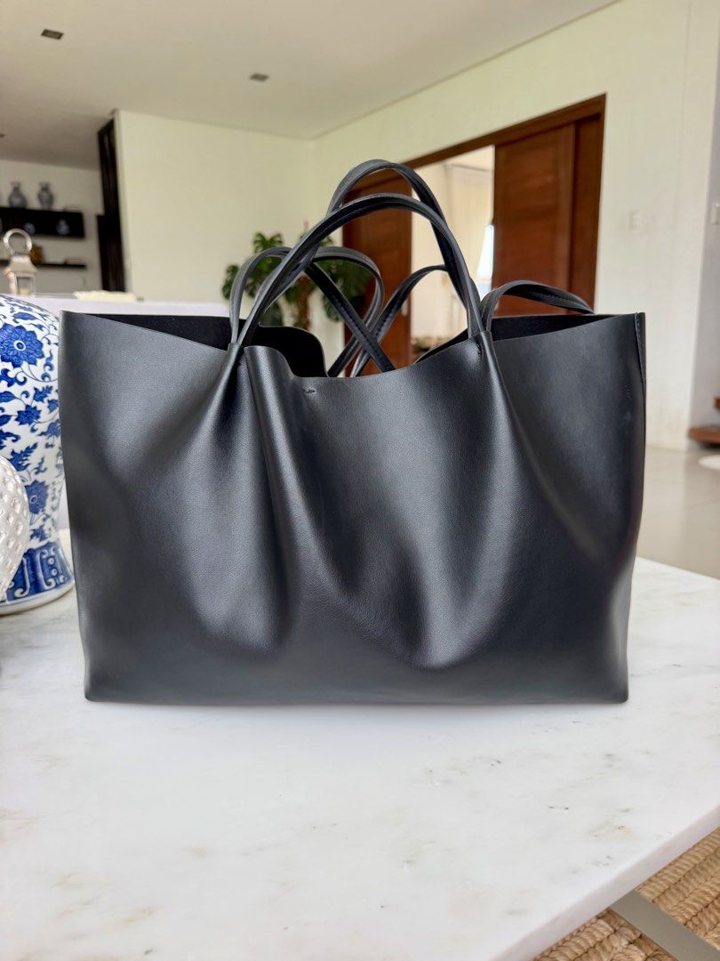 Zara Black Tote Bag (Category: Tote Bags) located in Lipa City. Submitted by pauline0303 (Listing ID 1468710963, Image 1). Description: - Authentic ZARA black tote bag - Double shoulder straps for comfortable carry on the shoulder or arm - Structured base keeps the bag upright - Center zippered compartment divides the interior - Clean black lining with embossed ZARA brand patch - Minimalist design perfect for daily commutes or errands - Flaw on s