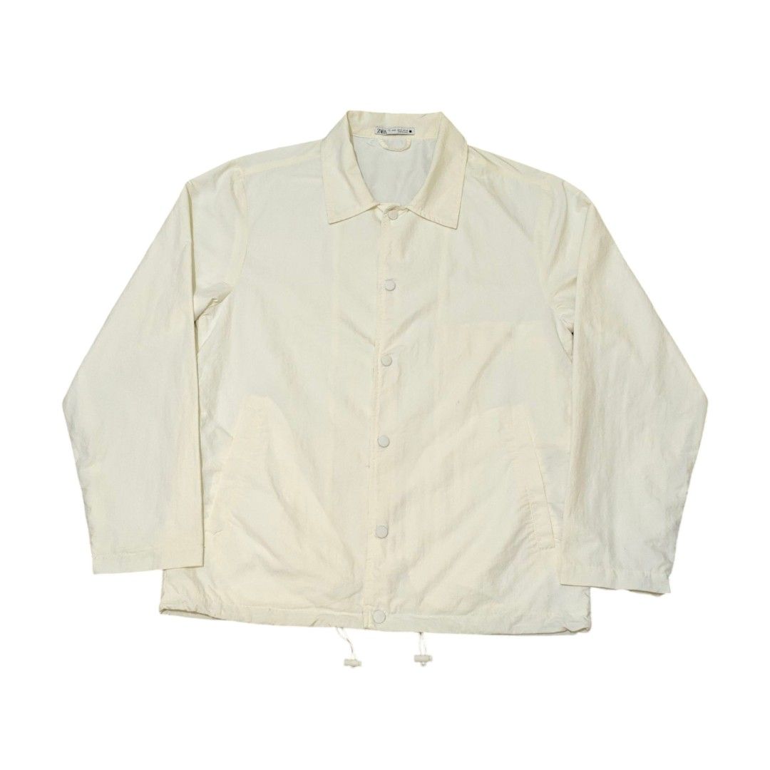 ZARA MAN Nylon Coach Jacket (Category: Coats, Jackets and Outerwear) located in Quezon City. Submitted by oldturnedtogold (Listing ID 1468600118, Image 1). Description: ZARA MAN Nylon Coach Jacket Size Medium White Shoulder Width - 19.5" Body length - 29" Chest Width - 22.25" Sleeve Length - 25.5" Details: - Nylon fabric - Lightweight and quick dry - Snap button closure - front welt pockets - adjuster on bottom hem - Shipping fee to be shouldered