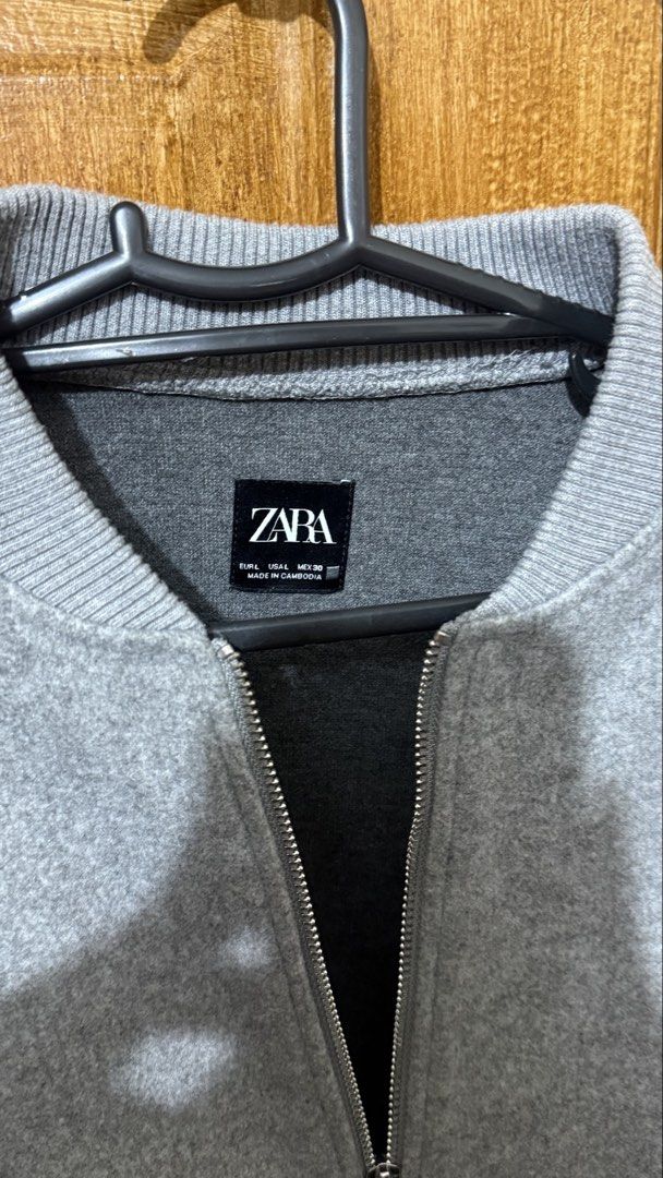Zara Soft Bomber Jacket (Category: Coats, Jackets and Outerwear) located in Makati City. Submitted by ario_drobe (Listing ID 1468680698, Image 2). Description: - Brand: Zara - Size: L - Color: Grey - Origin: Made in Cambodia - Closure: Full front silver zip - Details: Ribbed collar, cuffs, and hem, plus two front welt pockets - Material: Clean textured fabric exterior with dark grey inner lining - Fit & Style: Comfortable fit, perfect layering pi