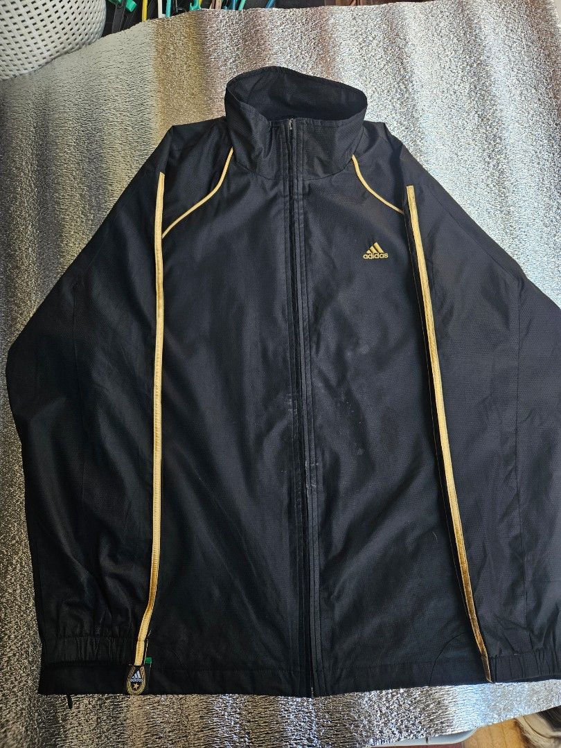🔥 ADIDAS Performance Track Jacket / Windbreaker 🔥 (Category: Coats, Jackets and Outerwear) located in Las Pinas. Submitted by thriftedjacketsbybang (Listing ID 1468738688, Image 2). Description: 🔥 ADIDAS Performance Track Jacket / Windbreaker 🔥 Upgrade your streetwear rotation with this clean black Adidas full-zip track jacket! Features a classic embroidered gold Adidas performance chest logo, an additional embroidered gold Adidas linear logo