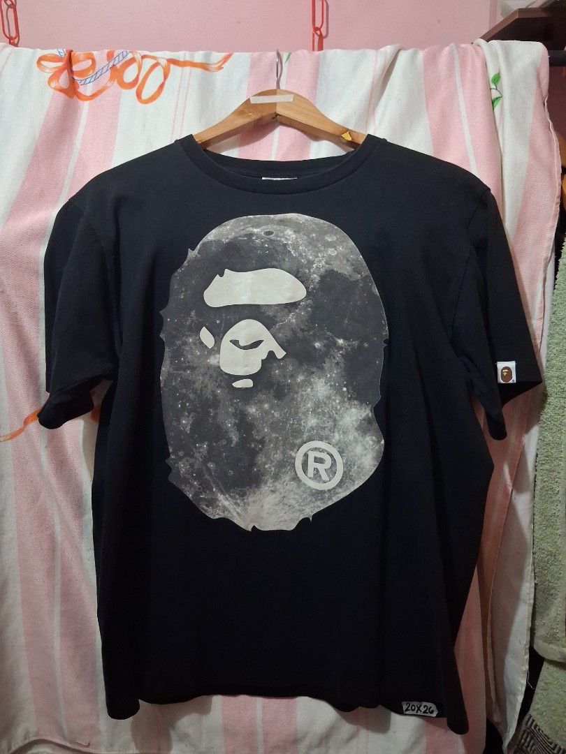 A Bathing Ape BAPE Moon Graphic Tee (Category: Tshirts & Polo Shirts ) located in Tarlac. Submitted by dwaynebarr31837 (Listing ID 1468822542, Image 1). Description: - Brand: BAPE (Nowhere Co., Ltd) - Color: Black - Size: Medium - Design: Large moon graphic on chest, signature ape head tag on sleeve - Material: 100% Cotton - Origin: Made in Japan - Condition: Clean, excellent overall condition.