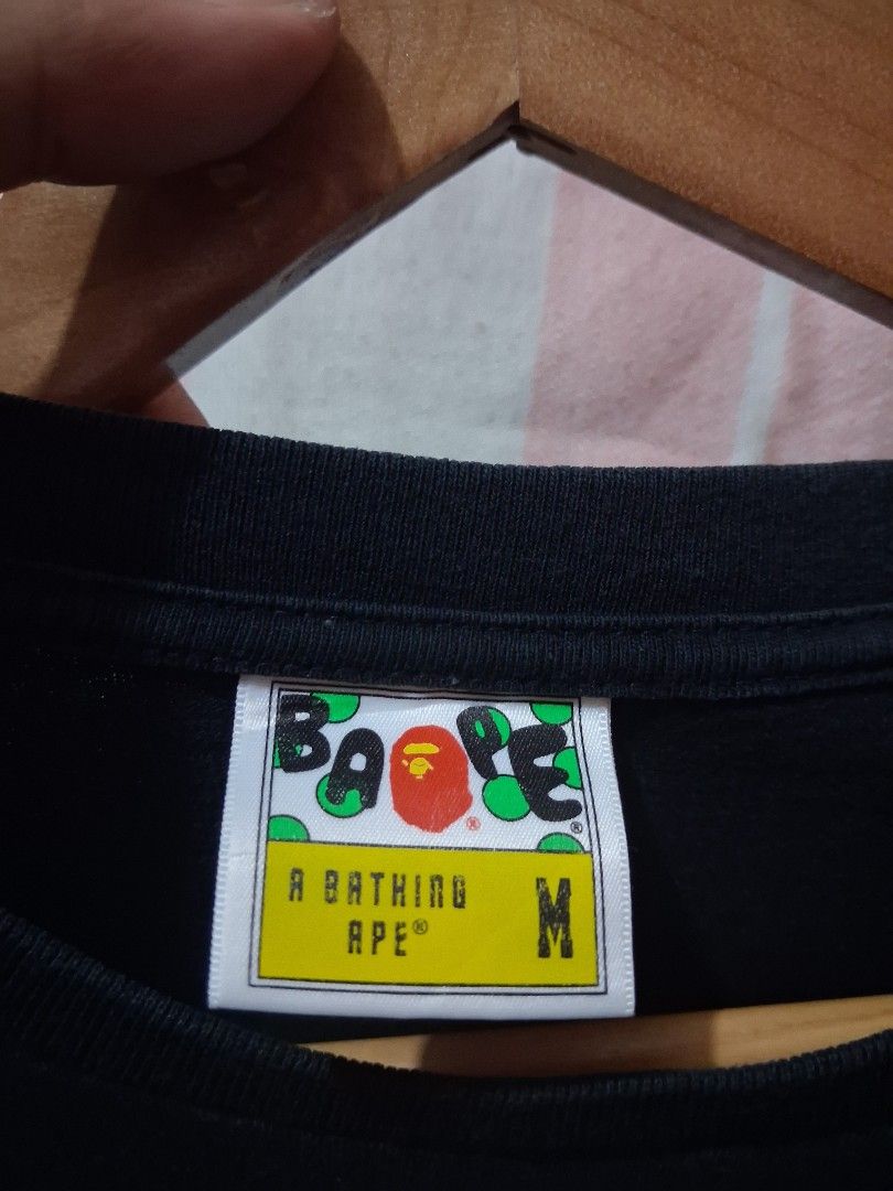 A Bathing Ape BAPE Moon Graphic Tee (Category: Tshirts & Polo Shirts ) located in Tarlac. Submitted by dwaynebarr31837 (Listing ID 1468822542, Image 2). Description: - Brand: BAPE (Nowhere Co., Ltd) - Color: Black - Size: Medium - Design: Large moon graphic on chest, signature ape head tag on sleeve - Material: 100% Cotton - Origin: Made in Japan - Condition: Clean, excellent overall condition.