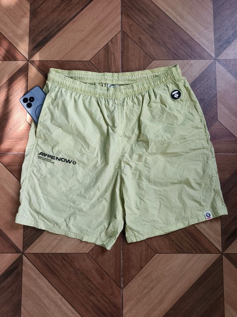 Aape By A Bathing Ape Nylon Short (Category: Shorts) located in Zamboanga. Submitted by d2977250664046 (Listing ID 1468879407, Image 1). Description: - Brand: Aape - Item: Nylon Shorts - Color: Light Green - Size: Large (34-36x20) - Waistband: Elastic with branded white drawstrings - Details: 'APE NOW' text print on right leg, circular Aape logo patch on left thigh, and small woven hem tag - Back: 'Somewhere in the Aape Universe' branding tag - P