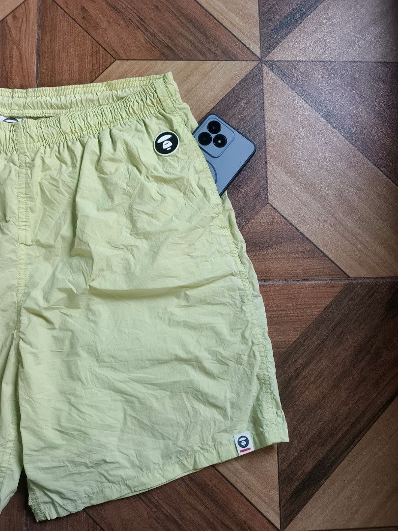 Aape By A Bathing Ape Nylon Short (Category: Shorts) located in Zamboanga. Submitted by d2977250664046 (Listing ID 1468879407, Image 3). Description: - Brand: Aape - Item: Nylon Shorts - Color: Light Green - Size: Large (34-36x20) - Waistband: Elastic with branded white drawstrings - Details: 'APE NOW' text print on right leg, circular Aape logo patch on left thigh, and small woven hem tag - Back: 'Somewhere in the Aape Universe' branding tag - P