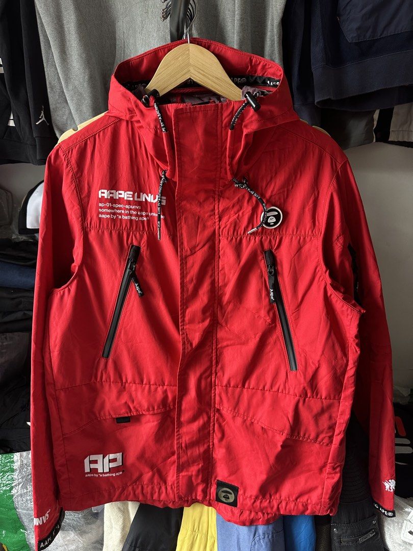 Aape by A Bathing Ape Red Hooded Jacket (Category: Coats, Jackets and Outerwear) located in Mandaluyong City. Submitted by nielc02 (Listing ID 1468751204, Image 1). Description: Size: M on tag Bestfit: Large Dimes: W21.5 x L27 Color rate: 10/10 Excellent condition No issue Minimal need wash - Authentic Aape by A Bathing Ape bright red jacket - Bold typography prints on the chest and sleeves - Stylish camo pattern panels near the cuffs - Adjustabl