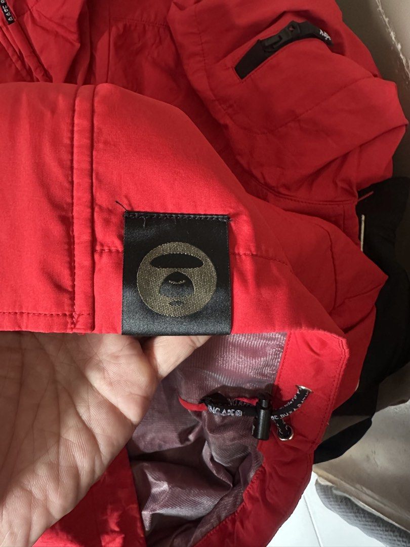 Aape by A Bathing Ape Red Hooded Jacket (Category: Coats, Jackets and Outerwear) located in Mandaluyong City. Submitted by nielc02 (Listing ID 1468751204, Image 3). Description: Size: M on tag Bestfit: Large Dimes: W21.5 x L27 Color rate: 10/10 Excellent condition No issue Minimal need wash - Authentic Aape by A Bathing Ape bright red jacket - Bold typography prints on the chest and sleeves - Stylish camo pattern panels near the cuffs - Adjustabl