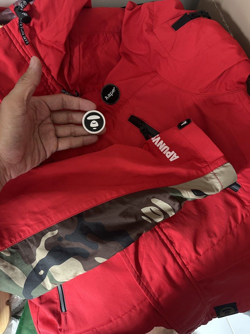 Aape by A Bathing Ape Red Hooded Jacket (Category: Coats, Jackets and Outerwear) located in Mandaluyong City. Submitted by nielc02 (Listing ID 1468751204, Image 2). Description: Size: M on tag Bestfit: Large Dimes: W21.5 x L27 Color rate: 10/10 Excellent condition No issue Minimal need wash - Authentic Aape by A Bathing Ape bright red jacket - Bold typography prints on the chest and sleeves - Stylish camo pattern panels near the cuffs - Adjustabl