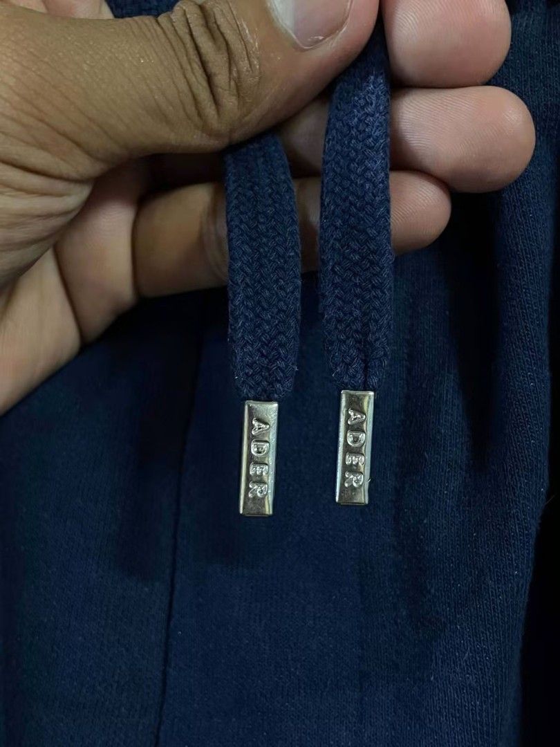 Ader Error Heart Sweatshorts Navy Blue (Category: Shorts) located in Manila. Submitted by ayskrim_ (Listing ID 1468788892, Image 2). Description: - Brand: Ader Error - Color: Navy Blue - Dimes: Length: 18 Leghole: 12 Waistline: 28-34 - Material: Premium thick cotton - Waistband: Elastic with adjustable drawstrings and branded metal aglets - Details: Blue embroidered heart patch with 'ADERERROR' and 'AFTER BLUE' lettering, side hem logo tag.