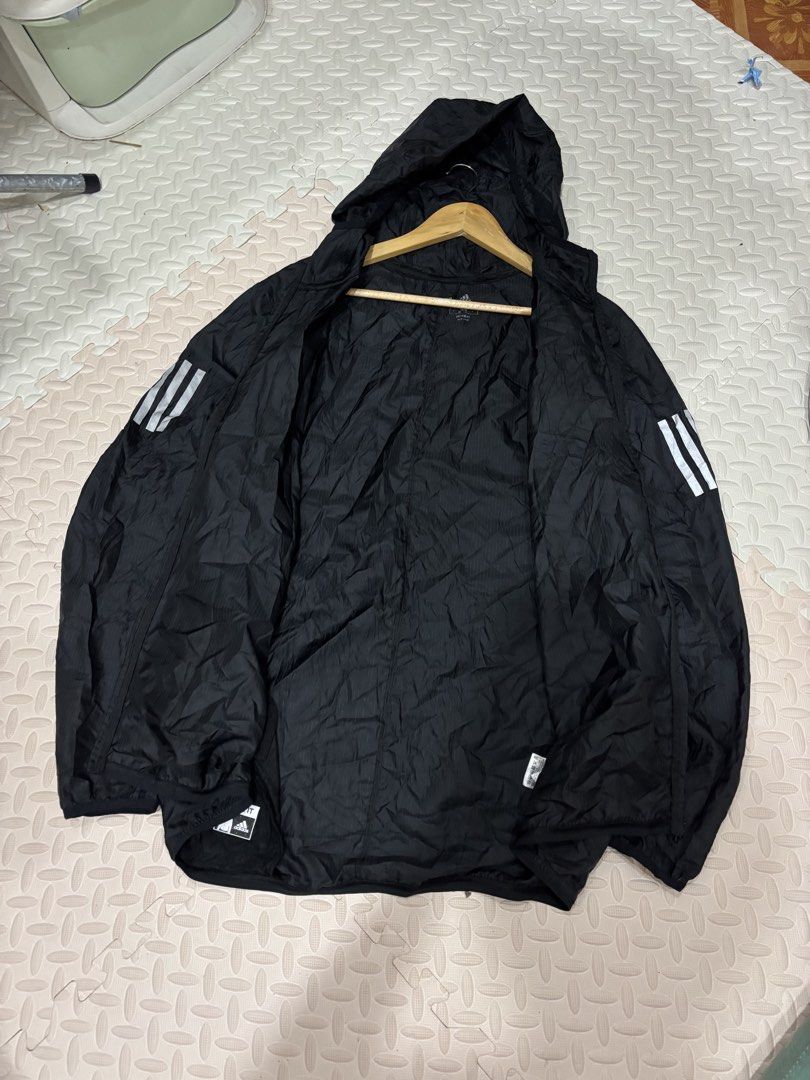 Adidas Black Running Windbreaker Hooded Jacket (Category: Coats, Jackets and Outerwear) located in Manila. Submitted by noribrahim.20 (Listing ID 1468873731, Image 2). Description: - Brand: Adidas - Color: Black with white 3-stripes and logo - Size: L (Made in Cambodia) - Material: Lightweight with subtle grid pattern texture - Features: Full-zip front, attached hood, and secure zippered side pockets - Condition: Great for running, training, or c