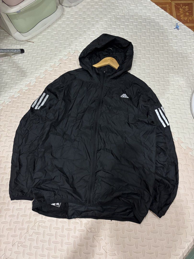 Adidas Black Running Windbreaker Hooded Jacket (Category: Coats, Jackets and Outerwear) located in Manila. Submitted by noribrahim.20 (Listing ID 1468873731, Image 1). Description: - Brand: Adidas - Color: Black with white 3-stripes and logo - Size: L (Made in Cambodia) - Material: Lightweight with subtle grid pattern texture - Features: Full-zip front, attached hood, and secure zippered side pockets - Condition: Great for running, training, or c