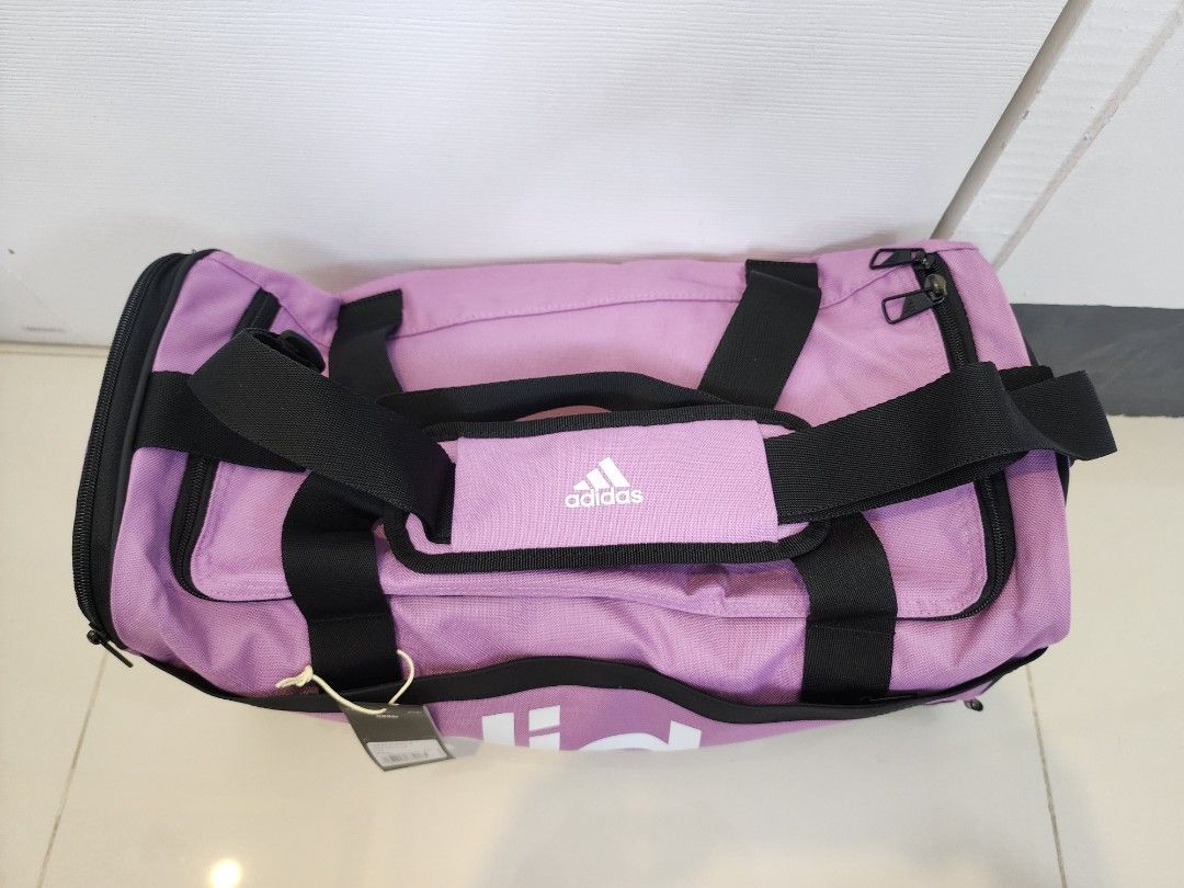Adidas Essentials Linear Duffel Bag (Category: Shoulder Bags) located in Quezon City. Submitted by pinkyshang (Listing ID 1468827186, Image 2). Description: - Brand: Adidas - Style: Adidas Essentials Linear Duffel Bag (Size: Small) - Color: Purple with bold White branding down the side - Condition: Brand new, unused with original tags attached - Features: Dual carry handles with padded grip - Storage: Zip main compartment and interior small slip 