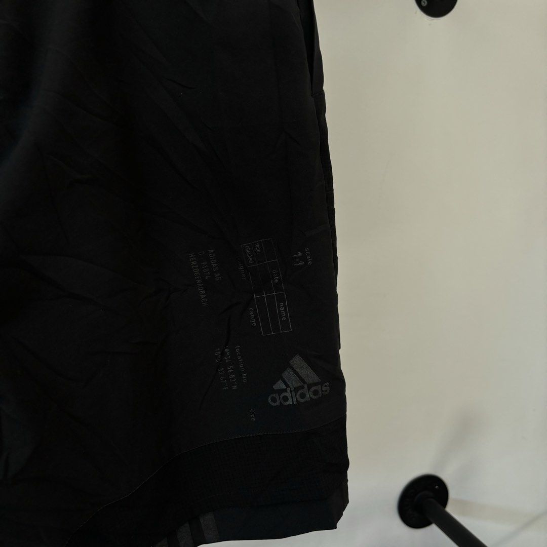 Adidas M Tech Shorts Black Size L (Category: Shorts) located in Bambang. Submitted by heats777 (Listing ID 1468818036, Image 3). Description: - Brand: Adidas - Style: M Tech Shorts / Techwear - Size: L - Material: 100% polyester - Waist: Elastic with bright pink integrated belt buckle closure - Details: Techwear graphics printed near the bottom hem on the back, multiple utility pockets - Condition: Clean, excellent overall condition.