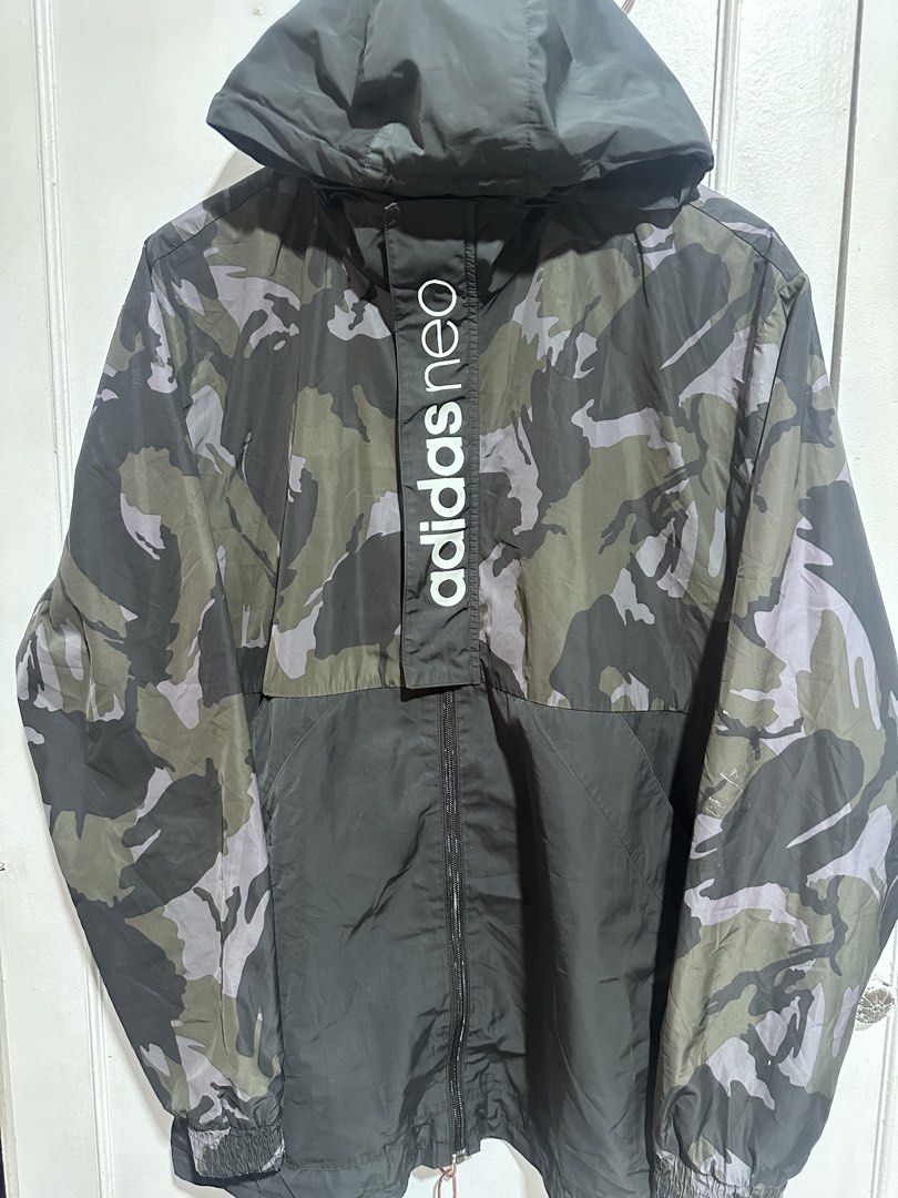 Adidas Neo Camo Windbreaker Jacket (Category: Coats, Jackets and Outerwear) located in Paranaque City. Submitted by cjc0622 (Listing ID 1468747446, Image 2). Description: - Brand/Model: Adidas Neo windbreaker - Design: Black and green camo pattern with a striking vertical logo along the half-zip placket - Features: Attached hood, full-zip closure, and comfortable elastic cuffs - Material: Lightweight fabric, ideal as an outer layer for breezy wea