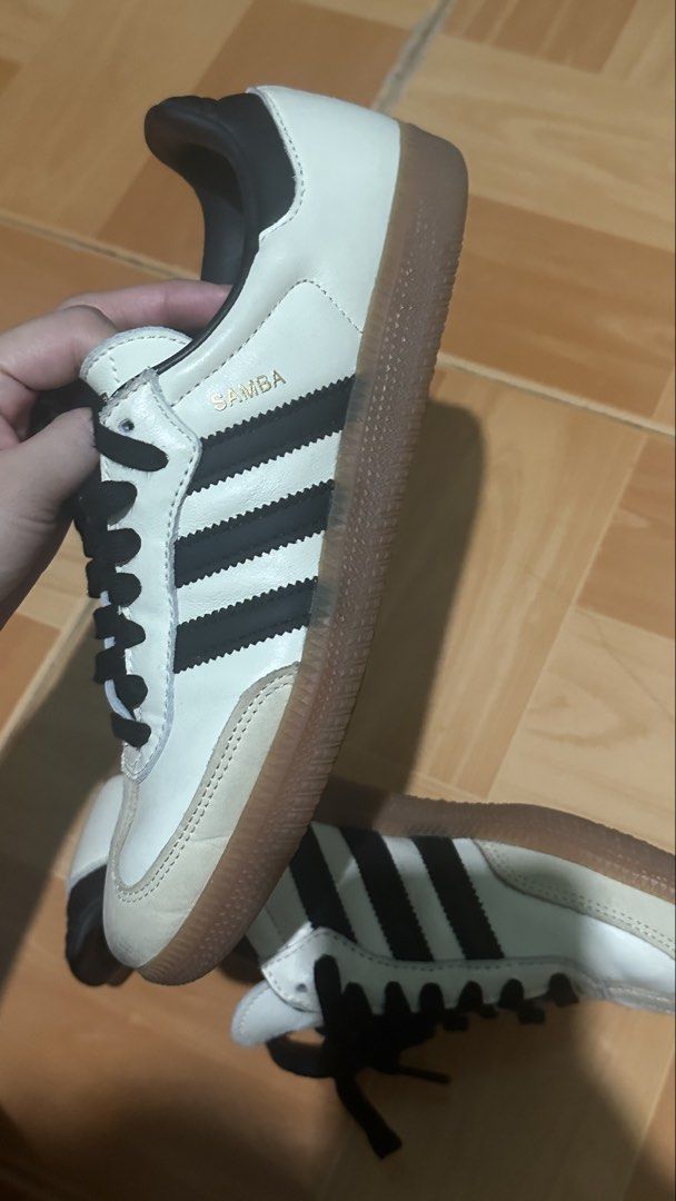 Adidas Samba Cloud White Core Black Shoes (Category: Sneakers) located in Manila. Submitted by declutterwzk (Listing ID 1468807817, Image 3). Description: - Brand: Adidas - Model: Samba - Colorway: White leather with black stripes and iconic gum sole - Details: Suede toe overlays, black heel tab, inner lining, and gold foil Samba branding - Condition: General wear on the suede toe and midsoles, structure and soles remain solid - Inclusions: Comes