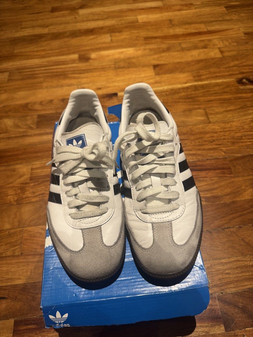 Adidas Samba OG White Black Cloud White B75806 (Category: Sneakers) located in Makati City. Submitted by raremixed (Listing ID 1468846306, Image 1). Description: - Brand: Adidas Samba OG - Colorway: White and Black leather with grey suede toe overlays - Features: Classic gum rubber outsole, blue tongue logo, and iconic gold foil lettering - Condition: Worn a few times, minimal signs of wear on soles and uppers - Inclusions: Original blue Adidas s