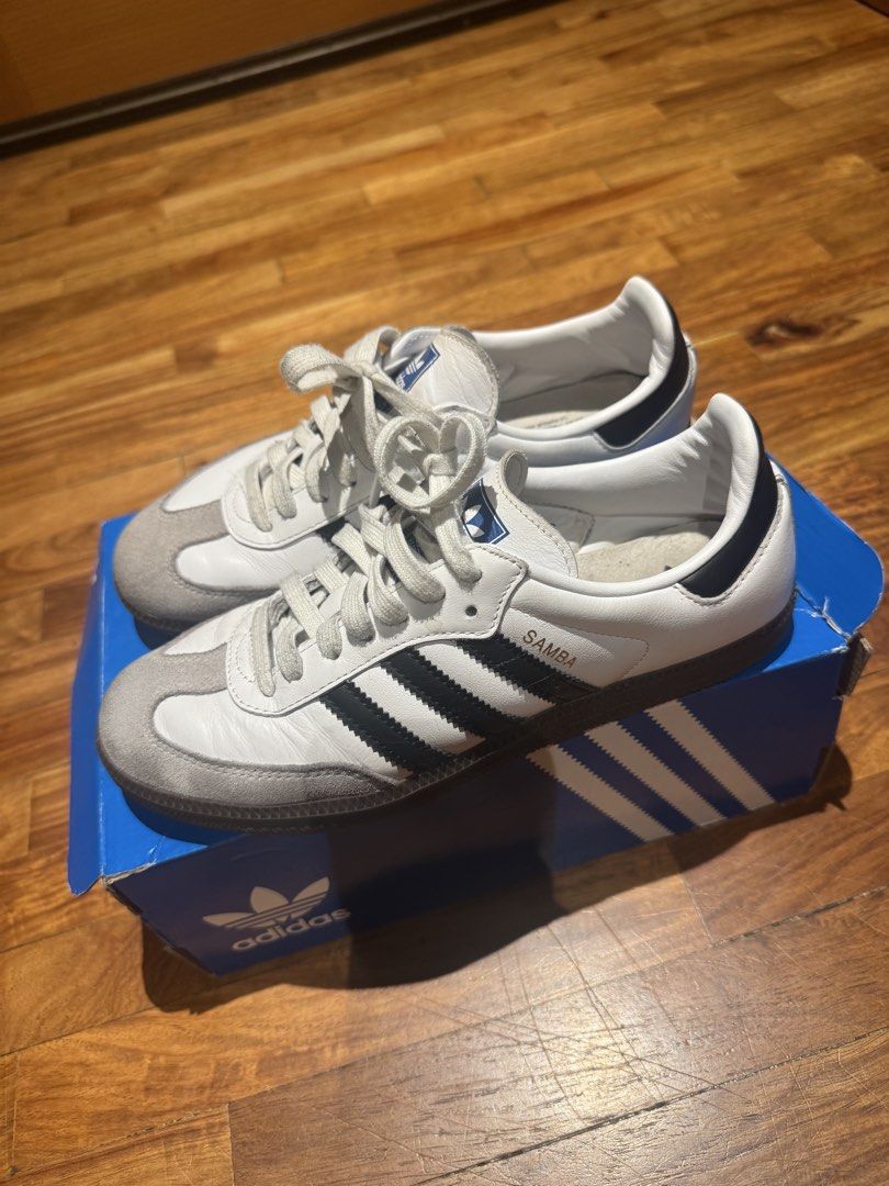 Adidas Samba OG White Black Cloud White B75806 (Category: Sneakers) located in Makati City. Submitted by raremixed (Listing ID 1468846306, Image 2). Description: - Brand: Adidas Samba OG - Colorway: White and Black leather with grey suede toe overlays - Features: Classic gum rubber outsole, blue tongue logo, and iconic gold foil lettering - Condition: Worn a few times, minimal signs of wear on soles and uppers - Inclusions: Original blue Adidas s