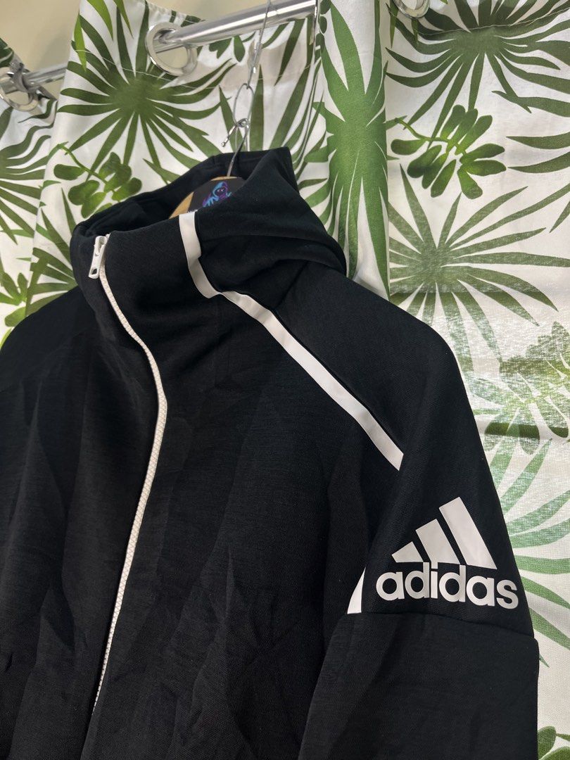 Adidas Techfleece (Category: Coats, Jackets and Outerwear) located in Caloocan City. Submitted by thriftywaps (Listing ID 1468870416, Image 2). Description: - Authentic Adidas full-zip hoodie - Color: Classic black with white accents - Distinctive large Adidas logo printed on the left sleeve - Features a high collar and attached hood for extra coverage - Stylish interior text print detailing inside the back lining - Size: Large (L) | Made in Indo