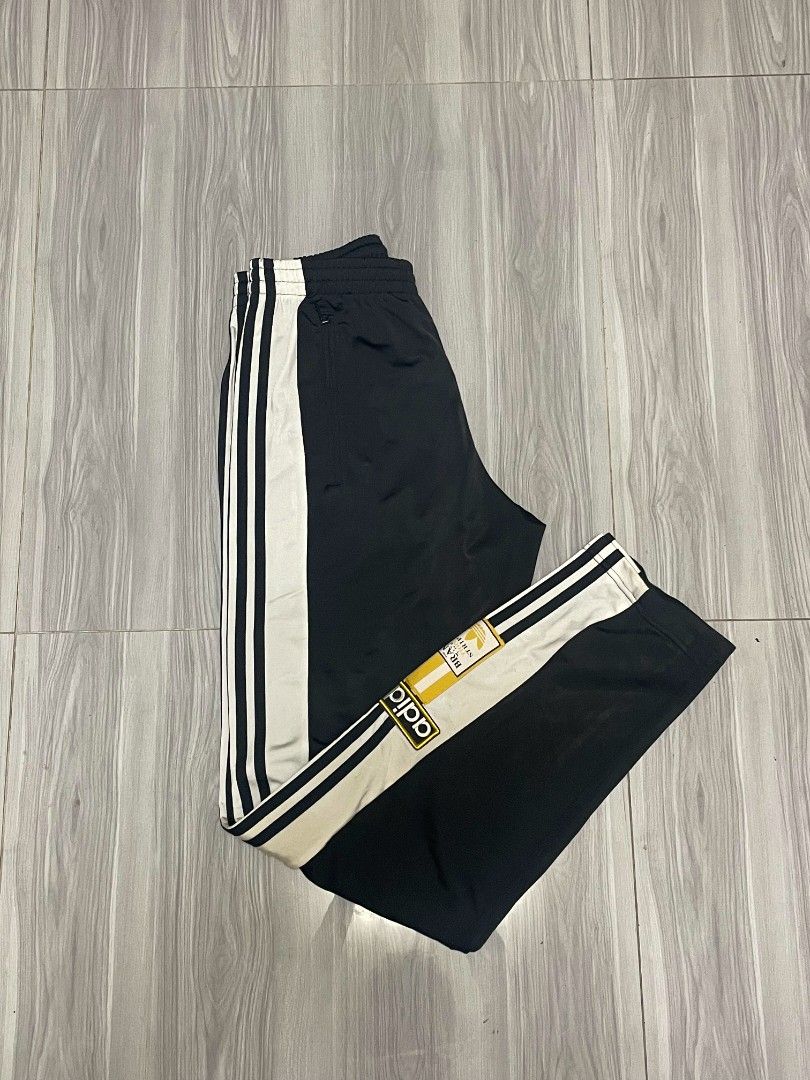 Adidas Track Pants Black White Snap Button Size M (Category: Joggers) located in Lipa City. Submitted by t1pce3garmentz (Listing ID 1468730158, Image 1). Description: - Classic black Adidas track pants - Size: M - Iconic wide white side stripes - Snap button details down the lower legs - Secure zippered side pockets - Comfortable elastic waistband with internal drawstring - Signature Adidas branding patches near the cuffs - Condition: Clean fabri