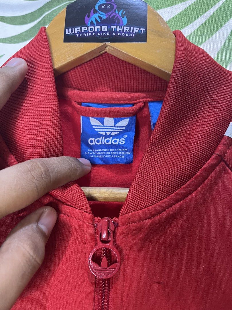 Adidas Trackjacket (Category: Coats, Jackets and Outerwear) located in Caloocan City. Submitted by thriftywaps (Listing ID 1468870281, Image 3). Description: - Brand: Adidas - Color: Bright red with classic white three stripes - Logo: White embroidered trefoil logo on the chest - Details: Full zip front closure with branded pull, ribbed collar, cuffs, and hem - Size: Tagged size 095 - Origin: Made in the Philippines.