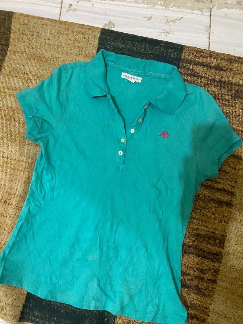 Aeropostale Turquoise Polo Shirt (Category: Shirts) located in Quezon City. Submitted by andreialej28522 (Listing ID 1468720385, Image 1). Description: - Brand: Aeropostale - Color: Turquoise with pink embroidered logo - Material: Soft, breathable cotton - Details: Classic button placket with white buttons - Fit: Standard fit, comfortable for daily wear.