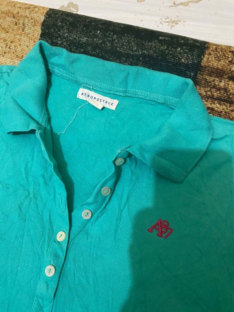 Aeropostale Turquoise Polo Shirt (Category: Shirts) located in Quezon City. Submitted by andreialej28522 (Listing ID 1468720385, Image 2). Description: - Brand: Aeropostale - Color: Turquoise with pink embroidered logo - Material: Soft, breathable cotton - Details: Classic button placket with white buttons - Fit: Standard fit, comfortable for daily wear.
